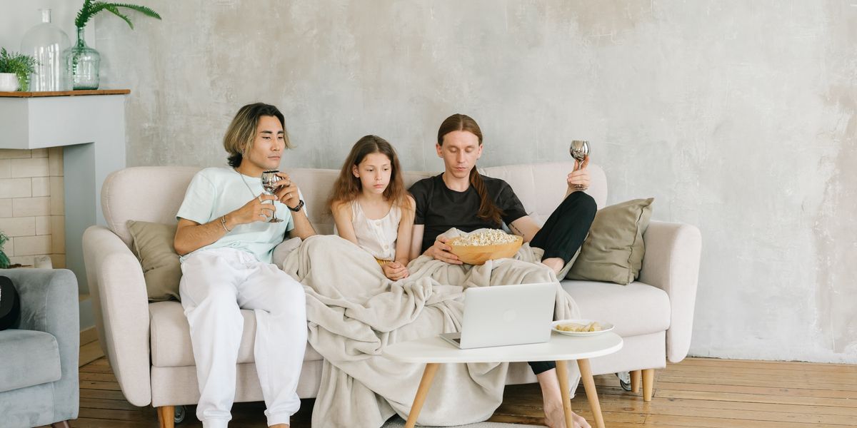 Three friends watching a video together on a laptop on the sofa